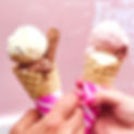 2 hands holding double scoop Gigi's Vintage Wonder ice cream cones