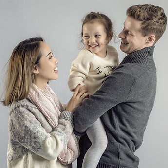 Laughing parents carrying their little girl