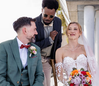 A loved one leans towards the couple during the ceremony
