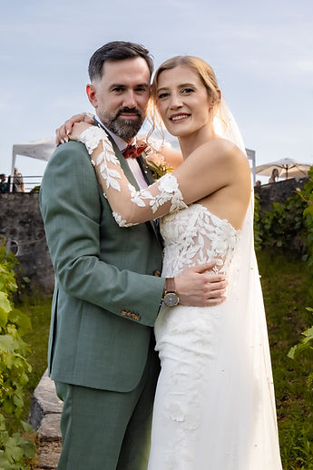 The couple smiling in the vineyards
