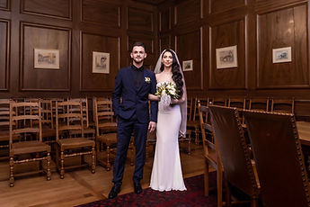 The newlyweds in the centre of the wood-panelled room