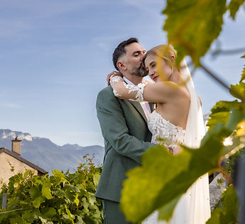 The couple embracing in the vineyards, behind the leaves