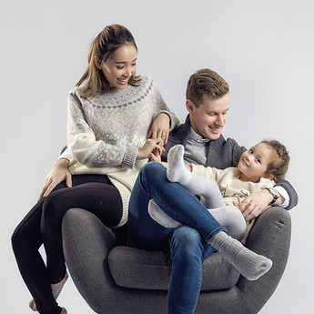 Parents and their child snuggled in an armchair