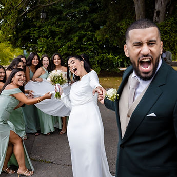 Joyful newlyweds surrounded by bridesmaids in green