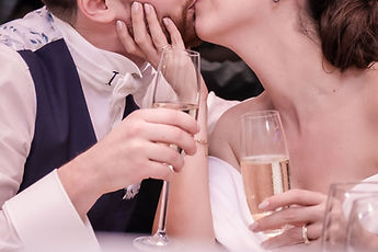 Detail: a kiss, champagne glasses in hand