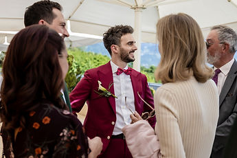 One of the grooms welcomes guests beneath the parasols