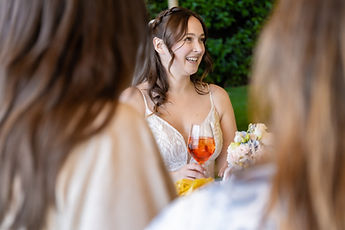 Lucie smiles between two guests, a spritz in her hand