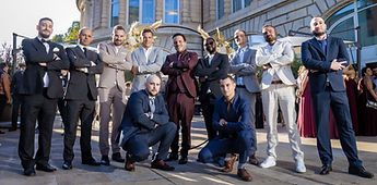 A group photo of the men in front of the façade
