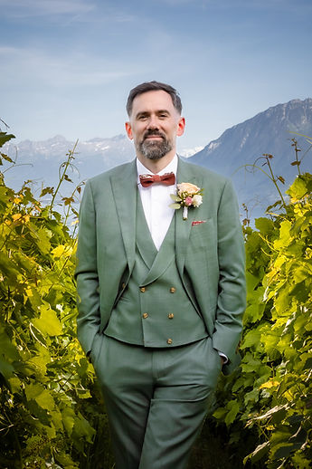 Portrait of the groom in a green suit and red bow tie
