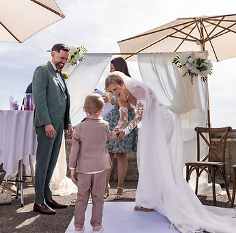 A little boy joins the couple beneath the arch