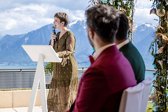 A loved one speaks at the lectern, the mountains behind her