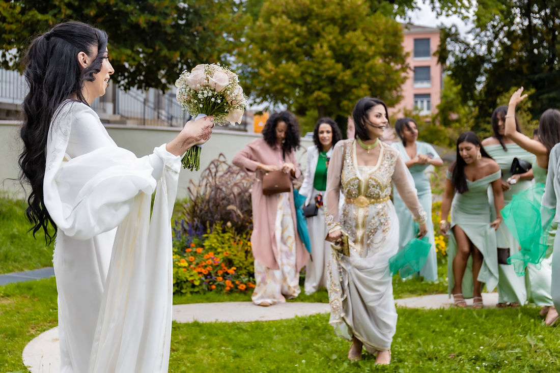 Leila lève son bouquet et danse sur la pelouse avec ses amies après la cérémonie, Mairie de Lancy