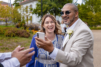 Two guests laugh over a phone screen