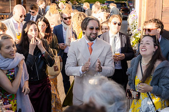 Derek clapping, surrounded by guests