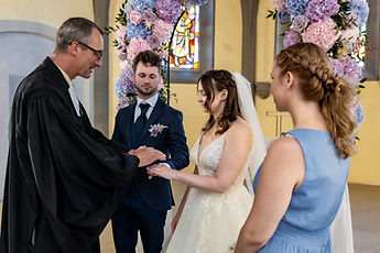The pastor takes the couple's hands in his