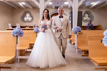 Lucie, bouquet in hand, walks towards the choir