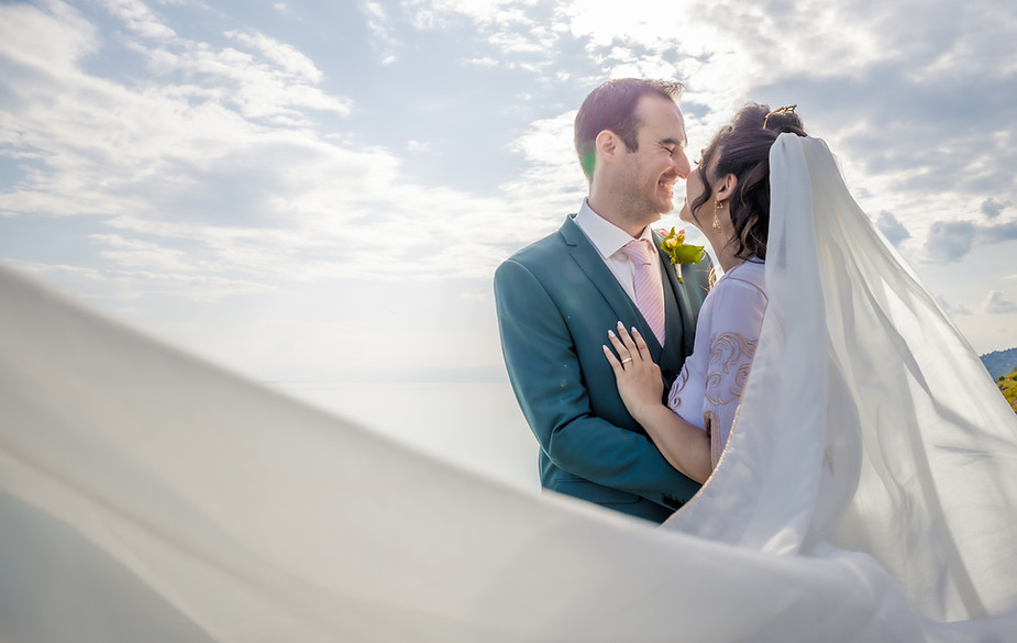 Mariés enlacés, le voile de la mariée porté par le vent