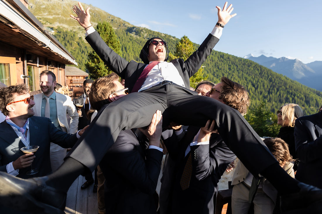 Un ami porté en triomphe sur la terrasse pendant le vin d'honneur, mariage à Chandolin
