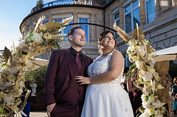 Sabrina and Idrisse under the flower arch, in front of the Lausanne Palace
