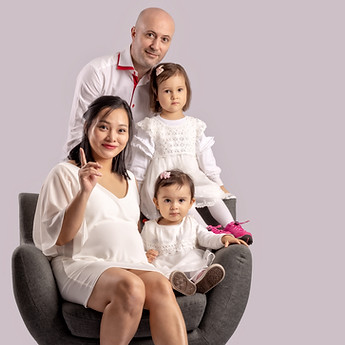 Mother-to-be seated with her two children, the father behind them, in the studio