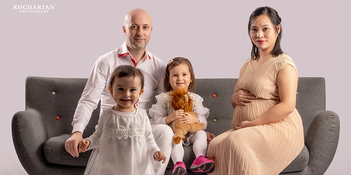 Family in the studio: the parents and their two children on a sofa