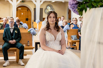 Lucie seated in the choir, the guests behind her
