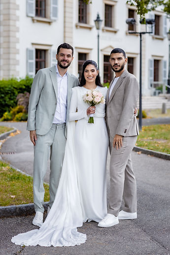 Leila between two loved ones in light suits
