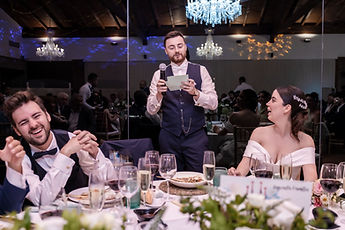 Jean gives his speech, microphone in hand, to laughter