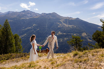 Charlotte and Derek walking hand in hand, facing the panorama