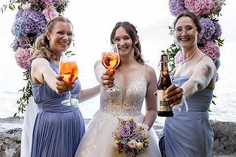 Lucie and her bridesmaids raise a toast beneath the flower arch