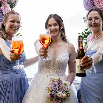 Lucie and her bridesmaids raise their glasses under the hydrangea arch by Lake Geneva