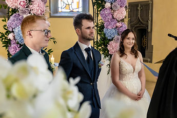 The couple standing, white flowers in the foreground
