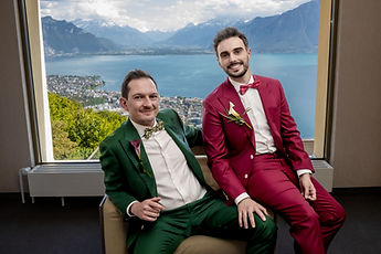 Portrait of the grooms by the picture window, the lake below