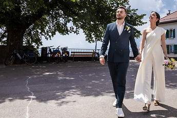 The couple walking under a large tree