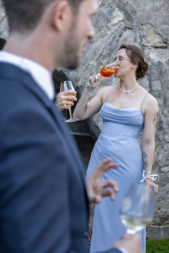 A guest raises her glass, Patrick from behind in the foreground