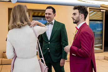 The grooms chat with a guest