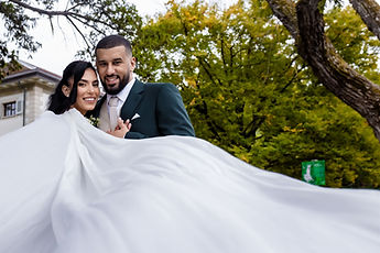The white cape in the foreground, the couple embracing