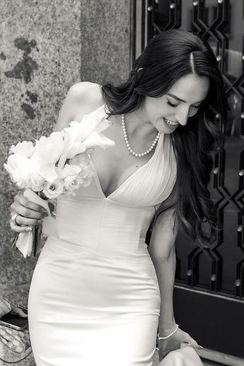 Albina looking down at her bouquet, in black and white
