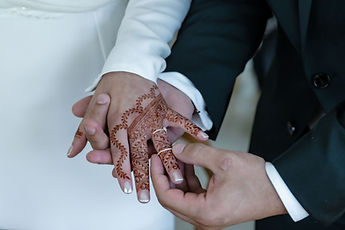 Detail: Marouan slips the ring onto Leila's hennaed hand