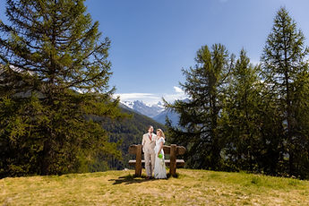Wide view: the couple between the trees, facing the valley