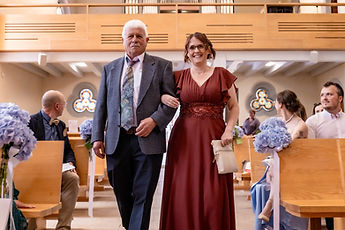Two guests walk down the aisle arm in arm