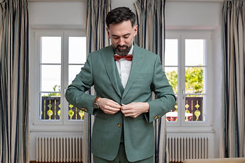 Adrien fastens his jacket in front of the windows