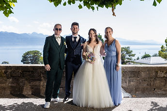 The couple with two loved ones in front of the lake