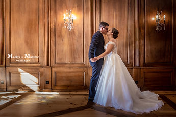 The newlyweds' kiss in front of the wood panelling of the wedding room