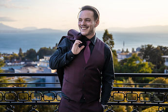 Idrisse laughing, jacket over his shoulder