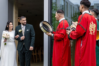 The musicians play frame drums as the couple come out
