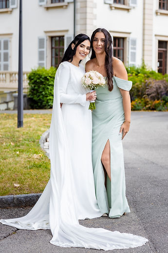 Leila and a friend in a soft-green dress, full length