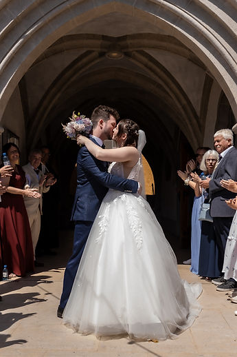 The couple embrace beneath the church porch