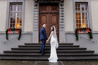 Hand in hand in front of the door, seen from behind