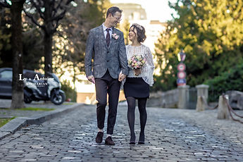 Ly and Antoine walking hand in hand on the cobblestones